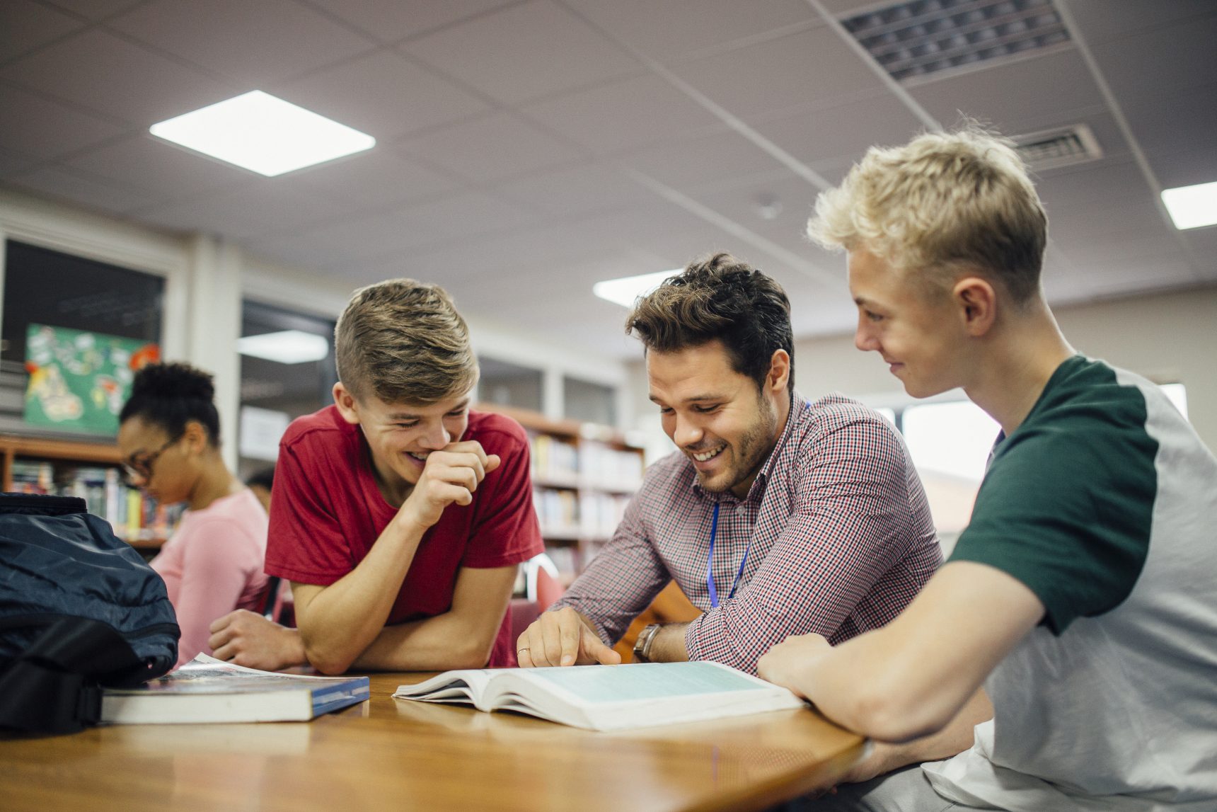 Two students receiving help from a teacher during homework club.