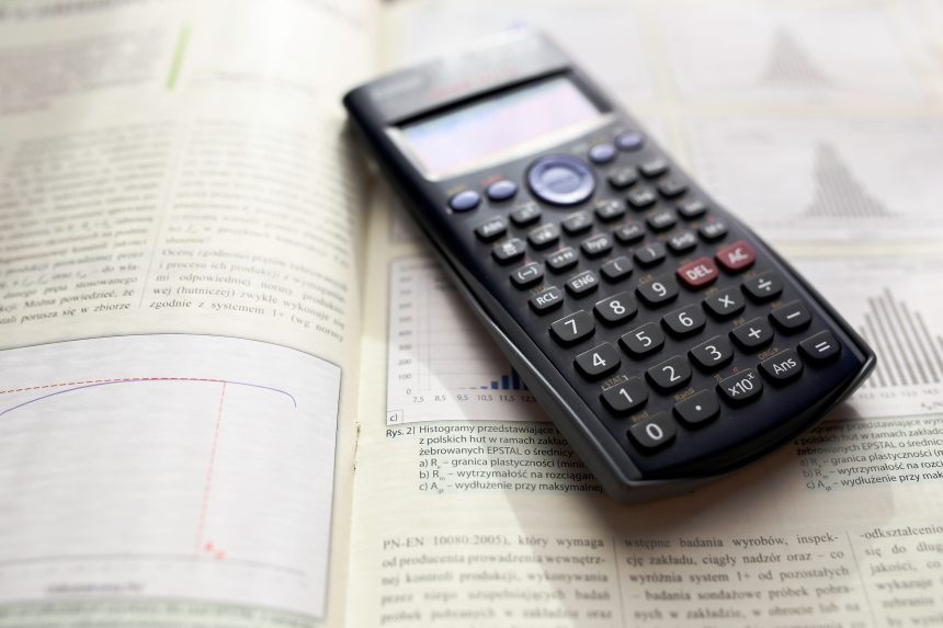 A calculator placed on top of an A Level Maths textbook. Students are typically allowed to use a calculator in A Level Maths exams.