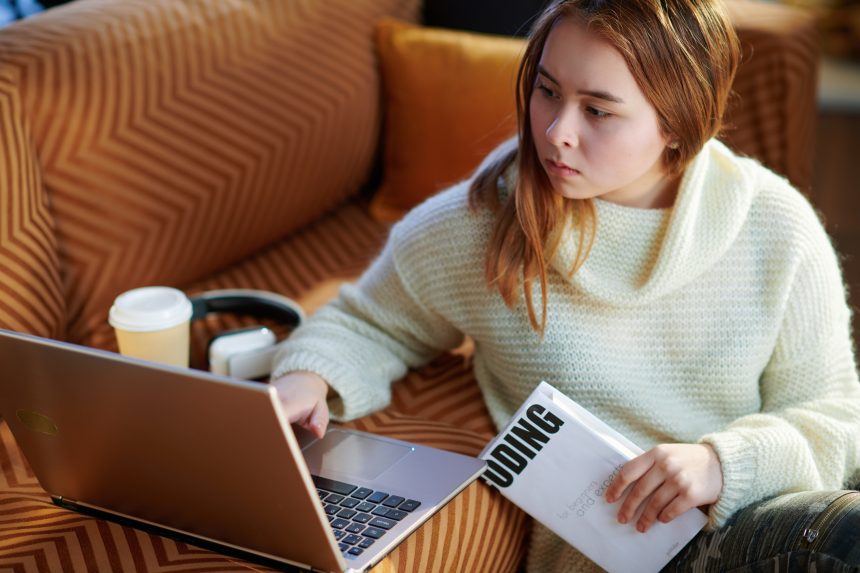 Young female reading a book about coding for her EPQ project.