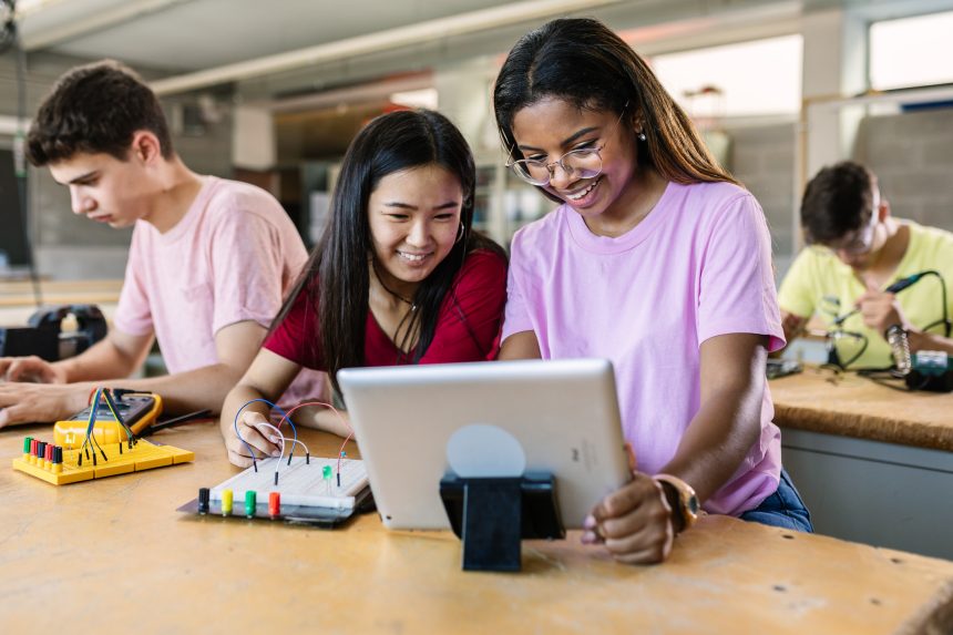 Two female technology students using their STEM skills to build an electronic circuit.