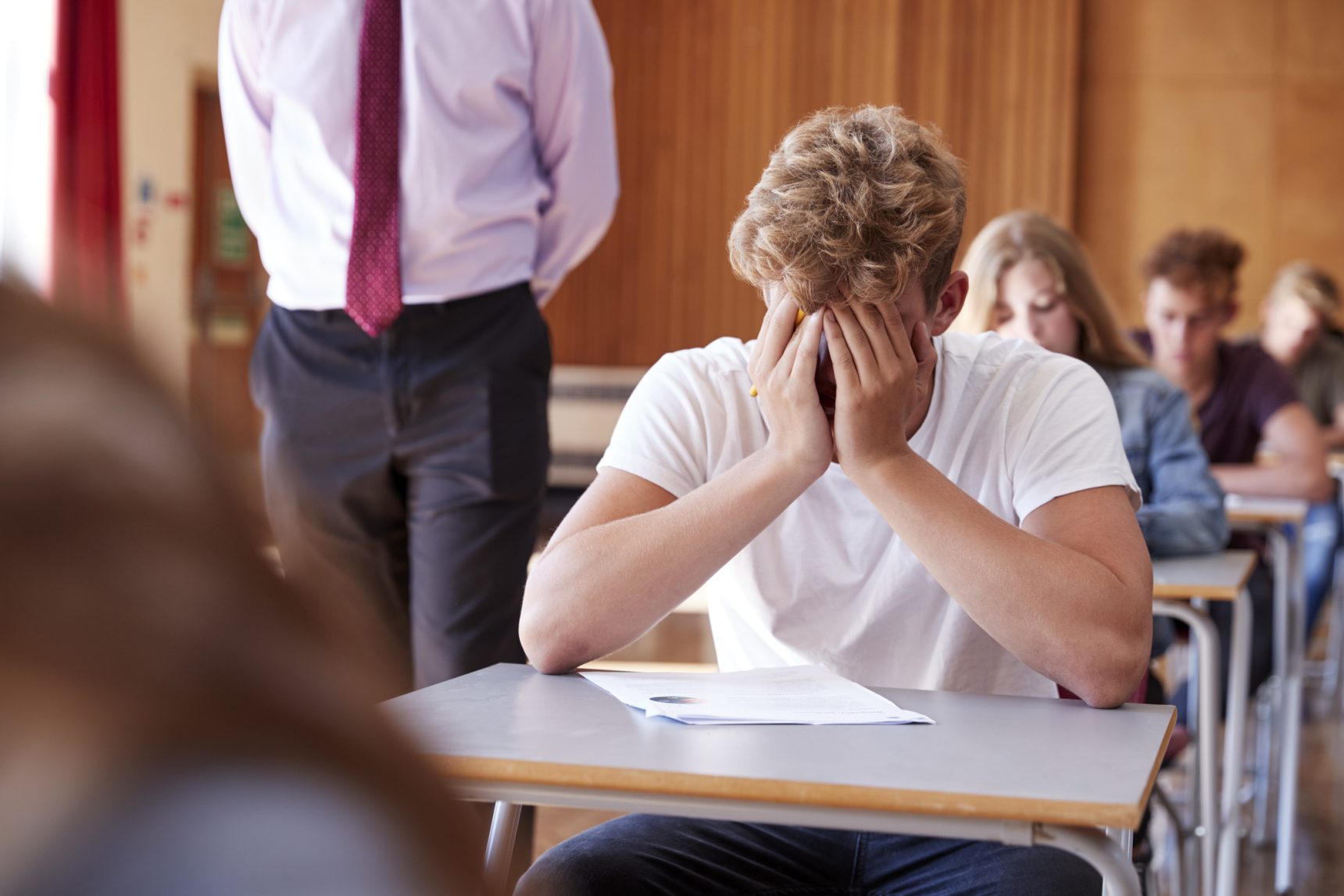 Stressed student in an exam hall.