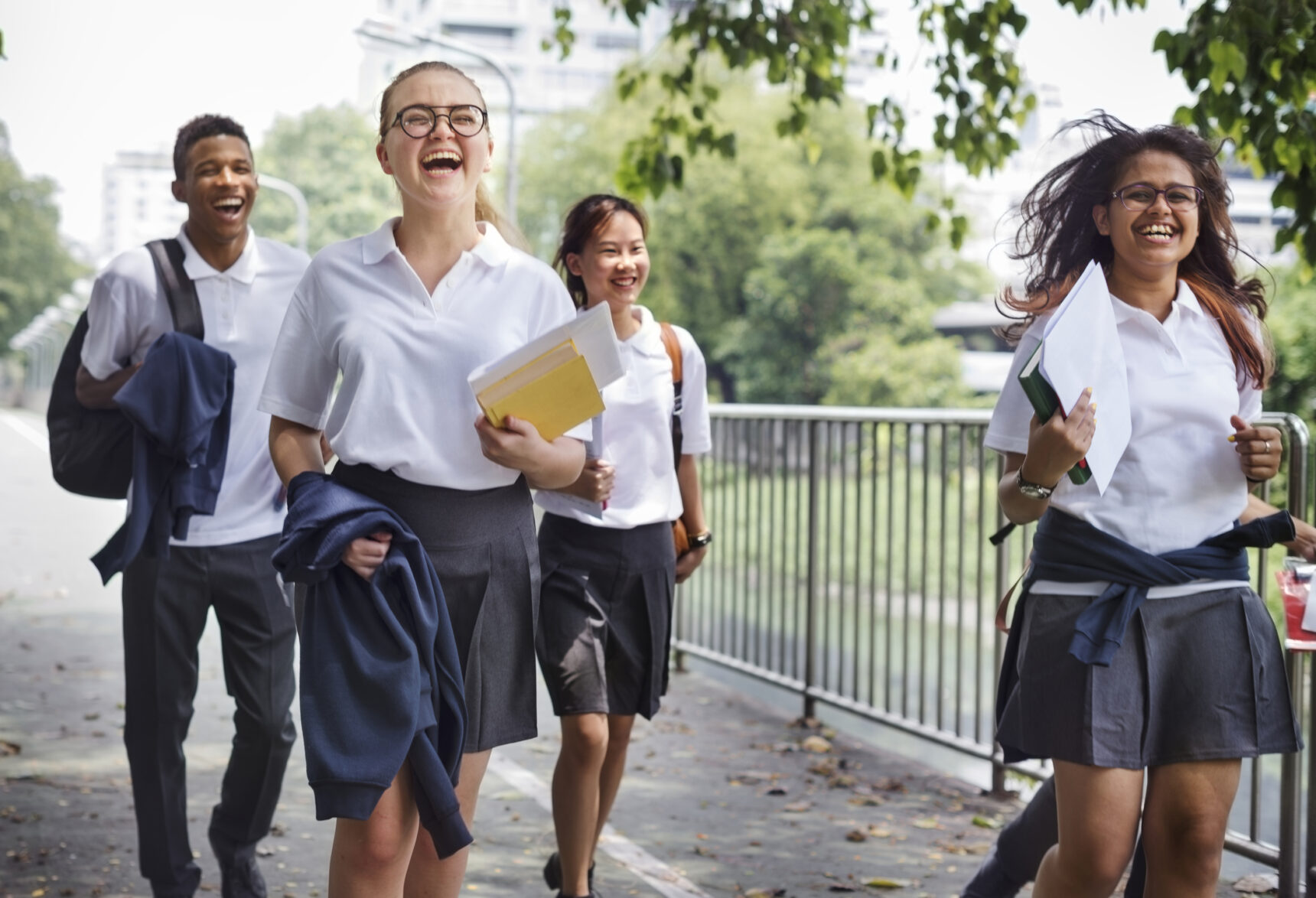 Group of smiling, happy students walking home from school.