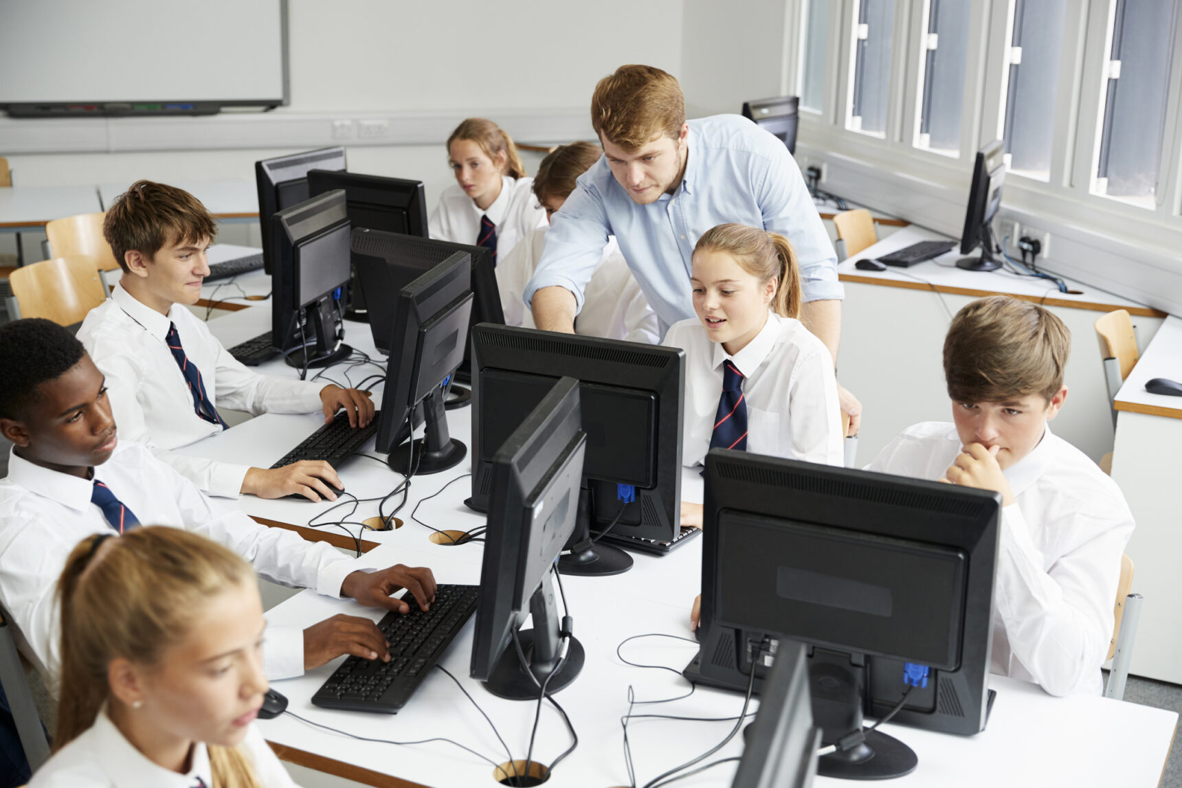 Teacher and students working in the computer classroom.