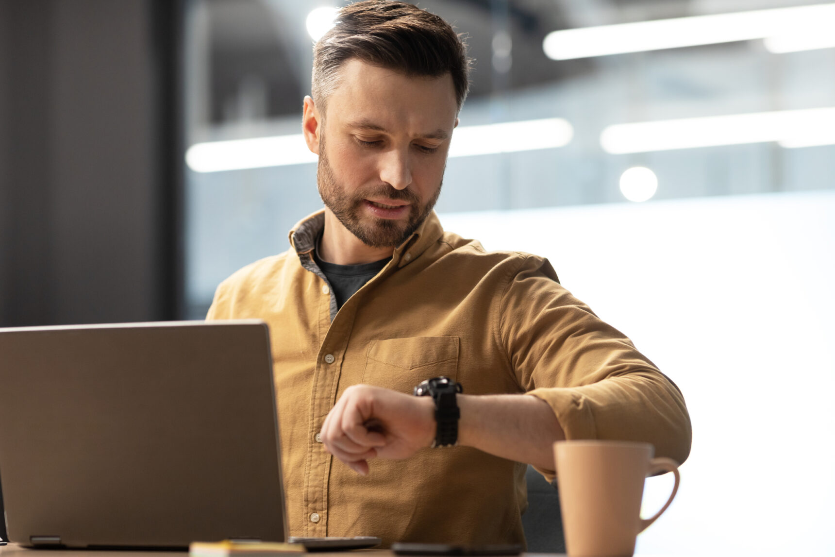 An online tutor is checking his watch to maintain an appropriate time boundary.
