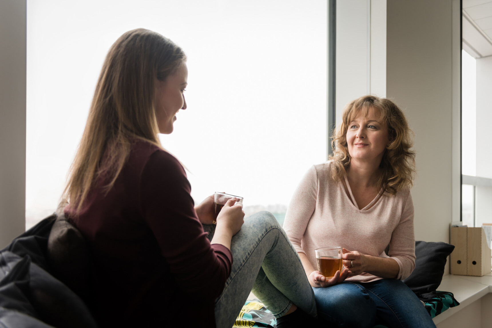 Mother and daughter drinking tea and chatting about university open days.
