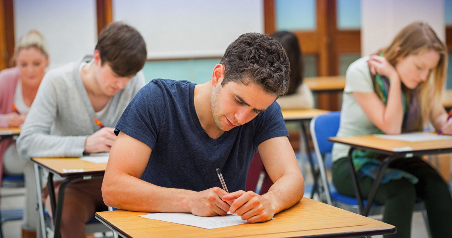 Male student sitting a written exam.