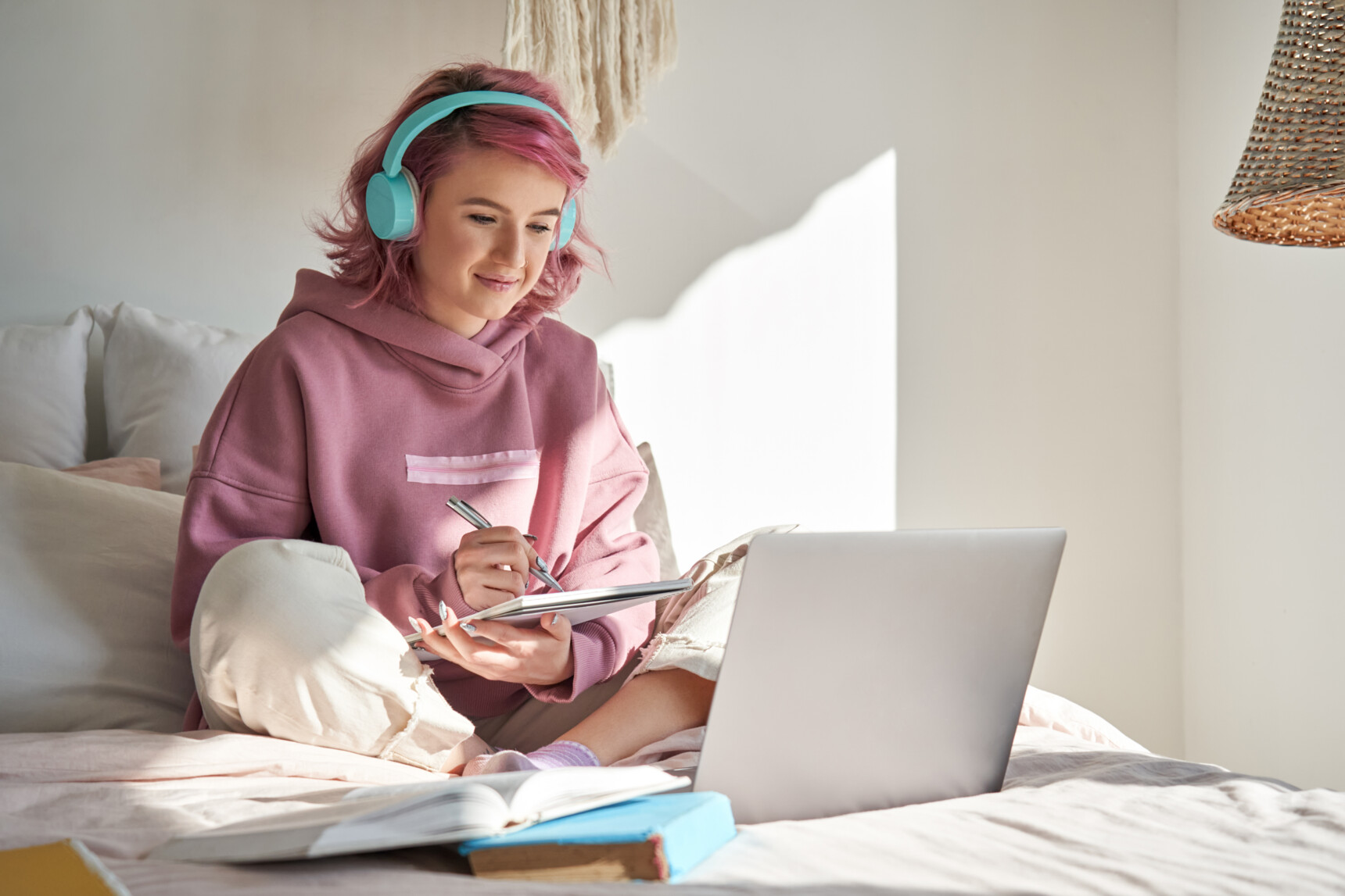 Teenage girl wearing headphones listening to a podcast for a supercurricular activity.