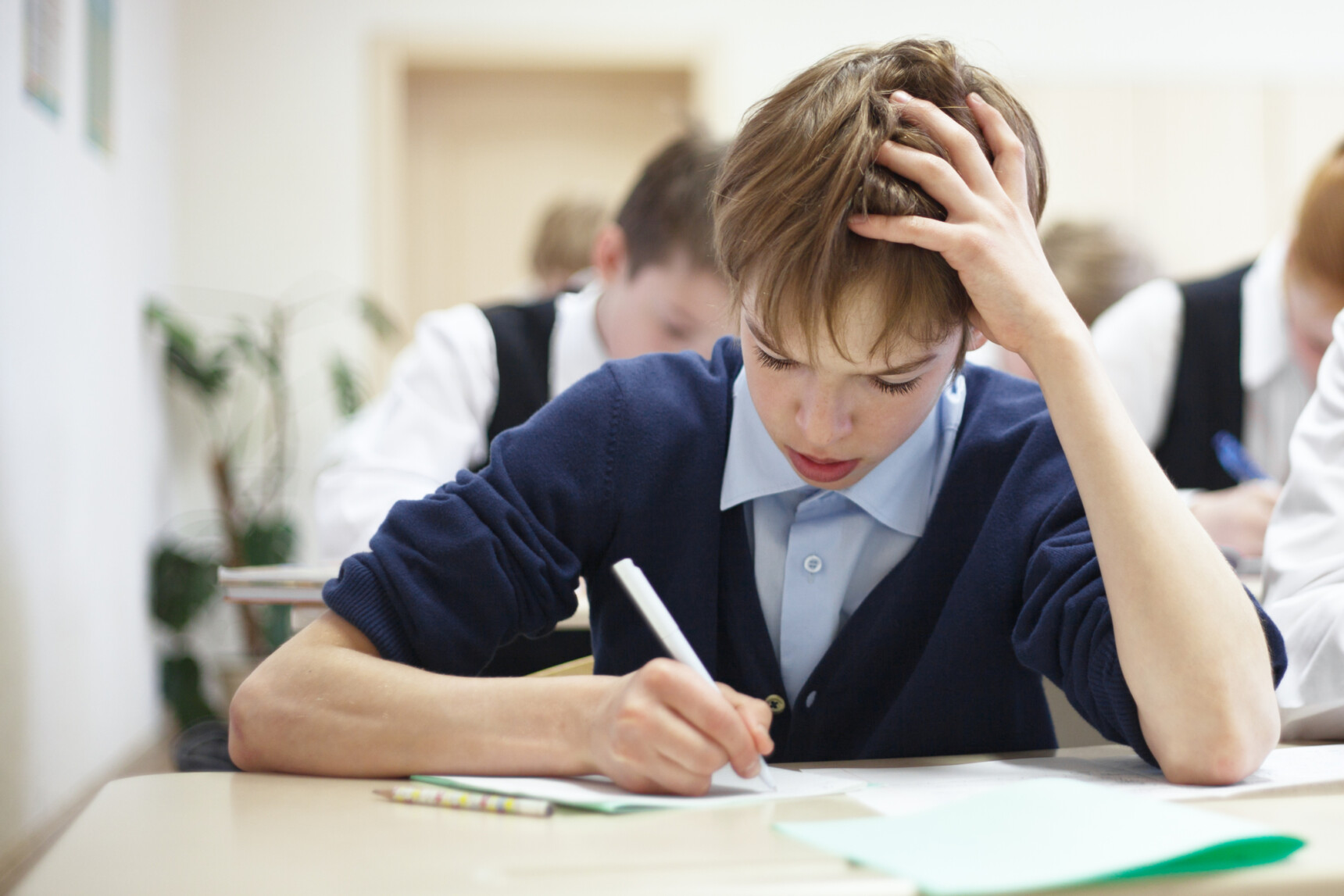 Teenage boy struggling in physics class.